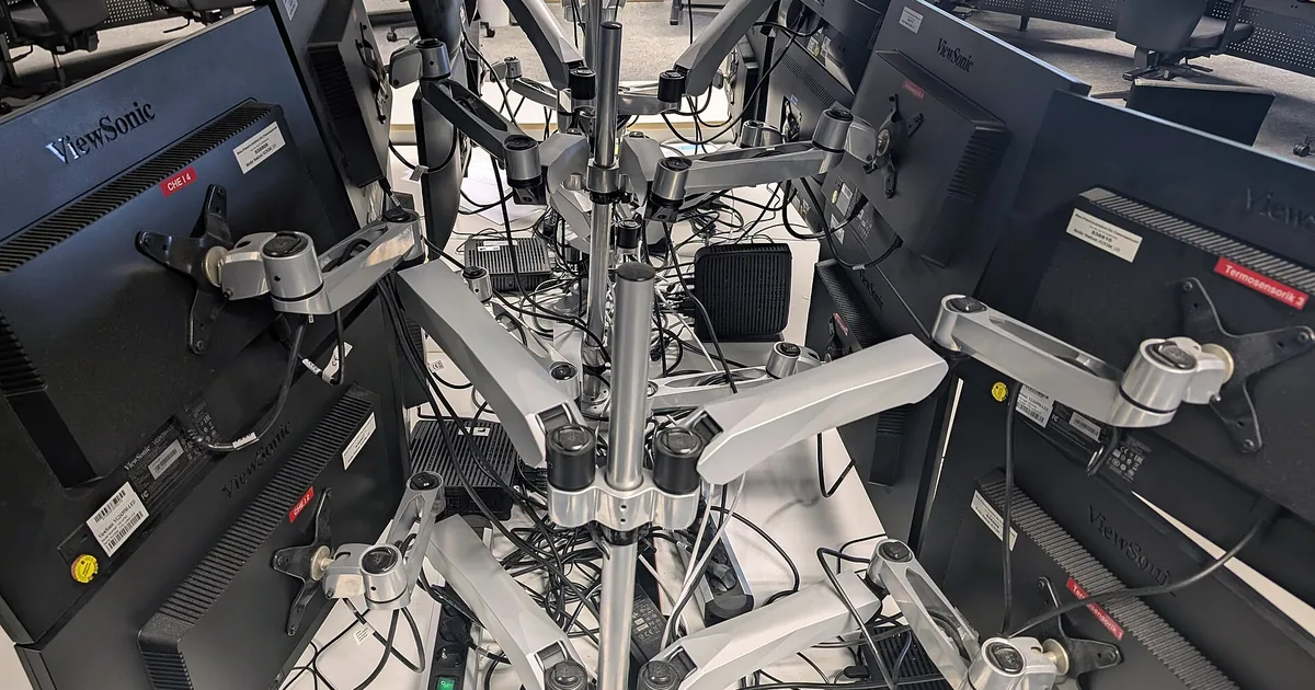 Una fila di postazioni identiche nella notte, ciascuna con una targhetta di colore diverso, collegate a una casa sotto la luna