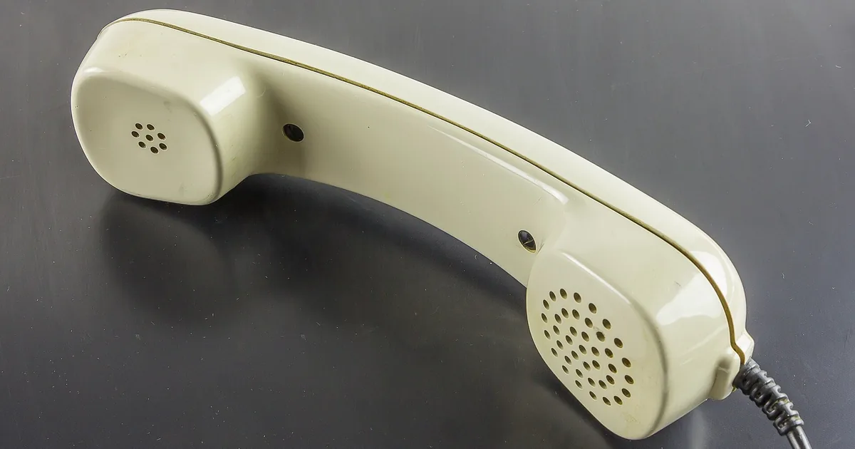 Una cornetta del telefono ambra nella notte indaco, con onde sonore rosa e viola che si allargano verso una luna crema