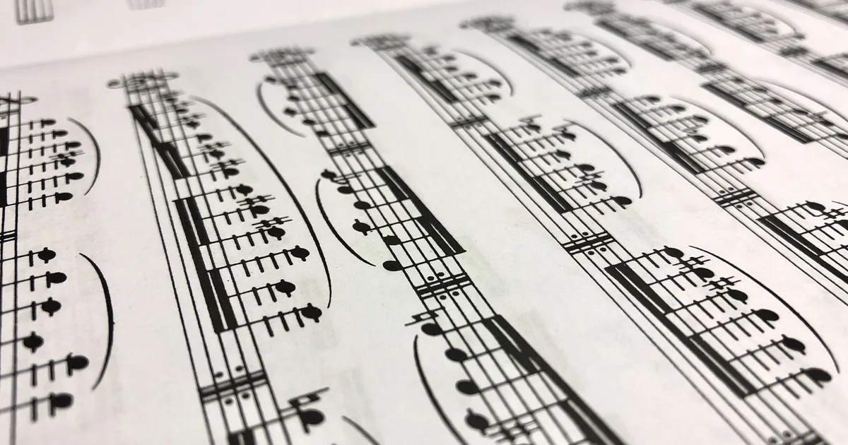 Una vecchia partitura su carta avorio, con un nastro bordeaux e una luce calda