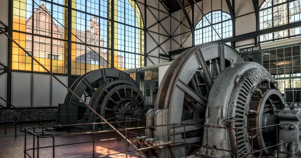 An old hydroelectric power station with its turbines at rest and morning light coming in through the high windows