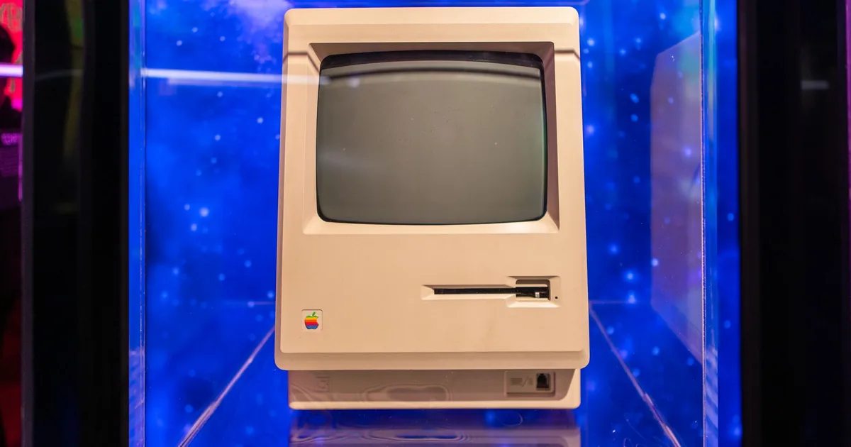 Una fila di piccoli computer compatti in alluminio impilati su una mensola da laboratorio, con i cavi raccolti